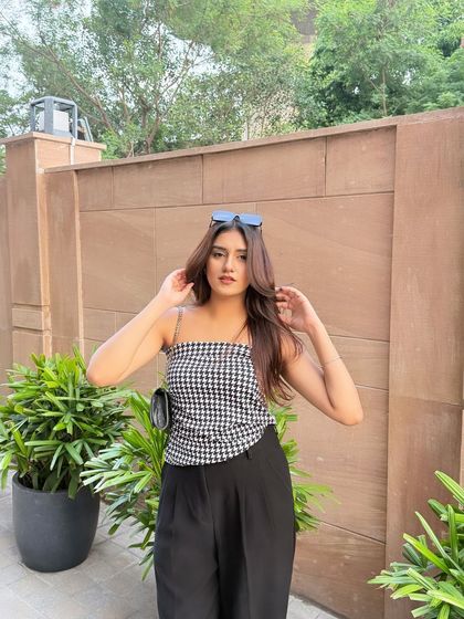 Grace in every movement. A simple, chic look with a houndstooth tube top and black wide-leg pants.