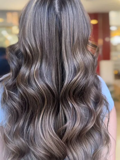 A fabulous caramel beige balayage. This close-up shows the intricate weaving of lighter pieces through the hair, creating a soft, multi-tonal effect that is incredibly flattering.