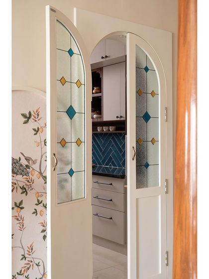 A closer look at the custom stained glass door for the kitchen. The geometric pattern in blue and yellow adds a touch of color and artistry, turning a functional door into a feature.
