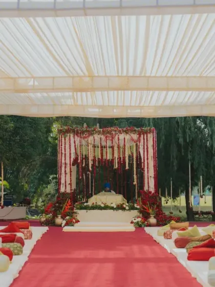 The setup for an Anand Karaj ceremony, with low seating and a clean, elegant mandap draped in white and red. I design spaces that are respectful of religious customs while maintaining a sophisticated aesthetic.