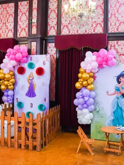 A view of the indoor game stalls, including a princess-themed bean toss and a tattoo station, ensuring the fun continues inside.