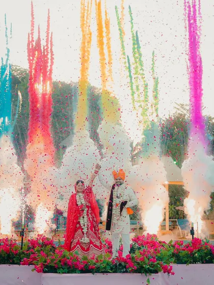 This is what pure celebration looks like. We love creating these spectacular, high-energy moments during the varmala ceremony, using elements like colored smoke to make your wedding photos unforgettable.