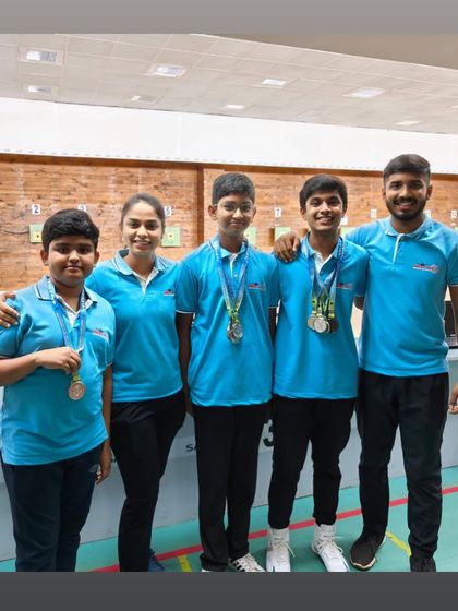 Our young Air Rifle men's team with their coach, proud of their performance and medals.