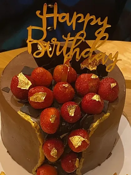 This is one of our signature styles, the chocolate strawberry fault line cake. The rich chocolate cake with a cascade of fresh strawberries and delicate gold leaf is the definition of pure indulgence.