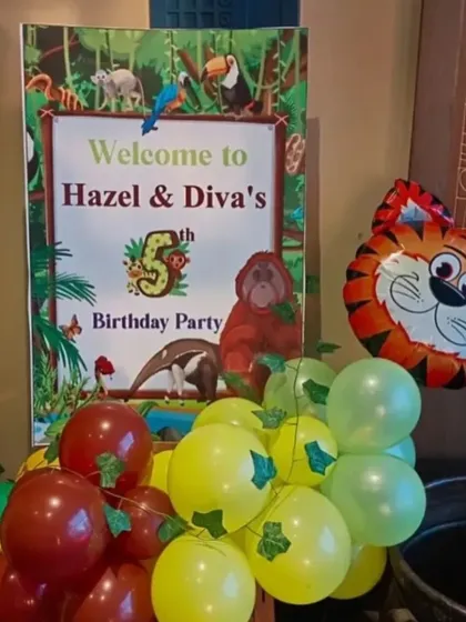 A personalized welcome sign for Hazel & Diva's jungle party, complete with a tiger balloon.
