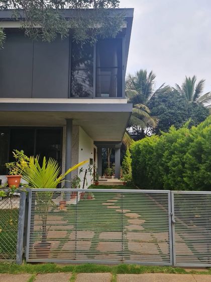 "Casa Magnifera" is a study in modern tropical architecture. The design features a simple cubic form with a cantilevered upper level, using a palette of grey cement board and exposed concrete to blend with the lush green surroundings.