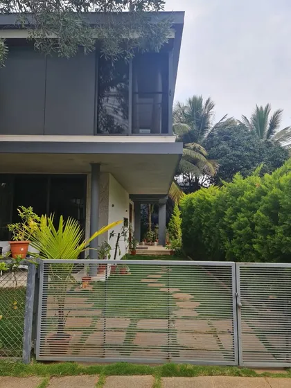 "Casa Magnifera" is a study in modern tropical architecture. The design features a simple cubic form with a cantilevered upper level, using a palette of grey cement board and exposed concrete to blend with the lush green surroundings.