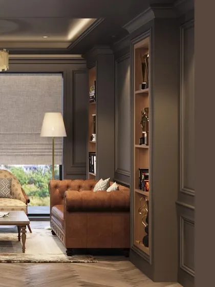 A detail shot of the office lounge area, showing a classic brown leather sofa and built-in shelving for awards and books. The design uses rich textures and a sophisticated color scheme to create a warm and inviting atmosphere.