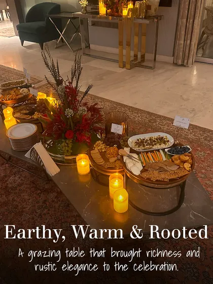 This grazing table was designed with an earthy, warm, and rooted theme. The rustic elegance of the wooden boards, candlelight, and rich colour palette brought a cozy and sophisticated feel to the celebration.