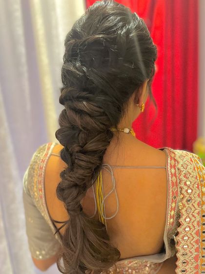 A voluminous and textured messy braid, perfect for a modern bride who wants a statement hairstyle.