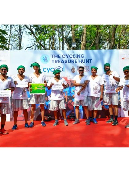 The winning farmer-themed team posing on stage with their prize at the Cycling Treasure Hunt.