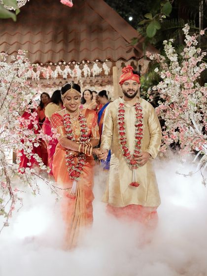 The couple's grand entrance through a cloud of smoke and cherry blossoms. This magical moment from their South Indian wedding looks like a scene from a fairytale.