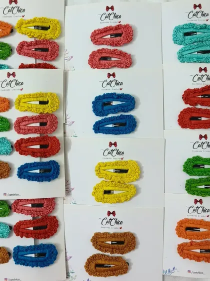 A full display of our colorful crochet clip sets. Each card holds a pair of clips in a single color, from sunny yellow to deep blue.
