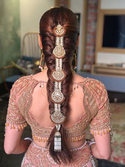 A detailed shot of the intricate braid and the stunning hair accessory, a key element in many traditional Indian bridal looks.