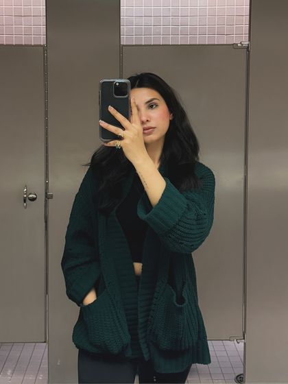A mirror selfie showing a cozy green cardigan, part of a "bits and pieces of my life" college-themed post.