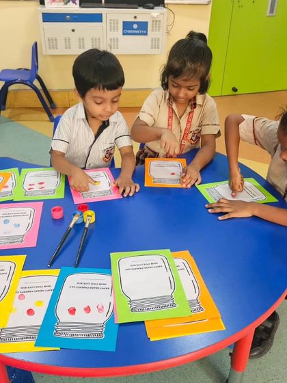 Students at a table are busy with a finger-painting craft for Grandparents Day. Our classrooms are hubs of creativity where children learn to express their emotions through art.