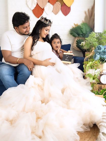 A candid moment during a family maternity session. The daughter's surprised expression as she looks at her mom's belly adds a touch of humor and realness.