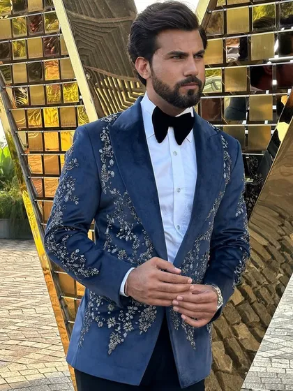 A masterpiece for your most important events. This hand-embroidered Nacre Tuxedo in a deep navy blue is crafted to ensure you are the center of attention. The intricate floral embroidery on the lapels and shoulders adds a layer of sophisticated detail.