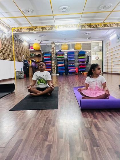 Even our youngest members learn the importance of stillness and focus. Here, two children are practicing Sukhasana, the easy pose, to calm their minds.