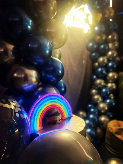 A close-up of a fun rainbow-shaped neon light I use as a prop. It adds a playful and colorful touch to birthday setups.
