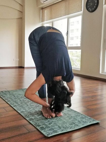 Let us energize the body and calm the nervous system. A student in Uttanasana (Standing Forward Bend), an essential pose for any practice.