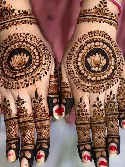 A striking mandala design with a lotus at its center, surrounded by intricate dot work. The bold, dark fingertips complete this festive look.