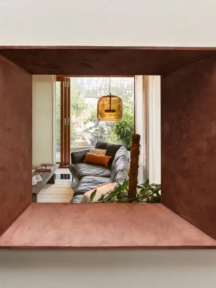 A conceptual detail shot, where a deep, copper-finished window frames a view into the living room. We use such portals to create layered views and intriguing glimpses between spaces.