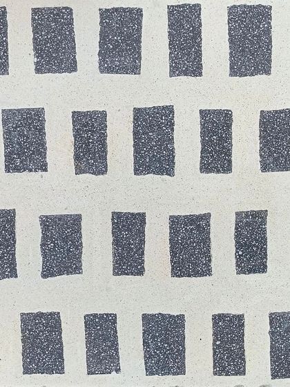 A close-up of our unshakable Venetian terrazzo experiment, featuring a pattern of grey terrazzo rectangles on a white base. Available in 600x600mm tiles.