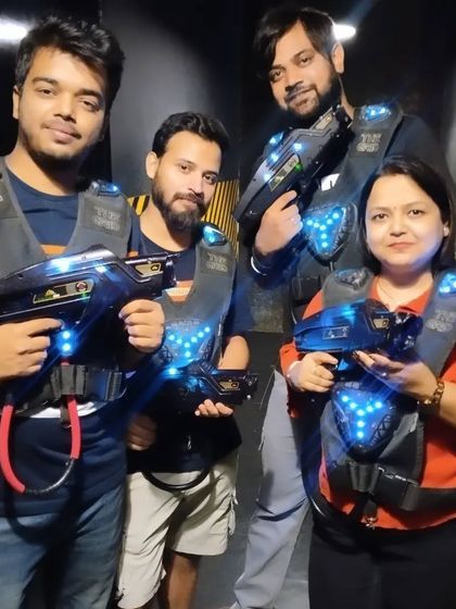 A squad enjoying a game of laser tag, with the glowing blue lights on their vests creating a cool visual effect.