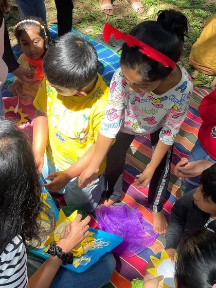 Hands-on creativity is a huge part of our sessions. Here, the children are gathered around for a craft activity, exploring textures and colors. These moments of making things together are just as important as the stories themselves.
