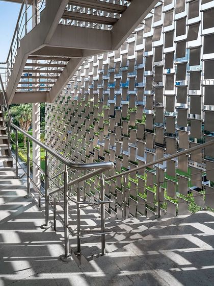 The experience of walking down the fire staircase is transformed by the 'shimmer screen,' which filters light and creates an unreal, ever-changing pattern of shadows on the interior.
