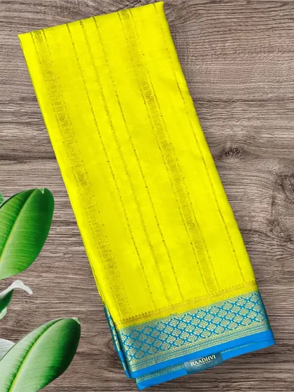 A bright and sunny yellow pure crepe Mysore silk saree with fine gold stripes and a contrasting blue border.