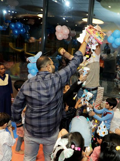 The piñata is always a moment of high excitement. Here, kids eagerly await the shower of treats.