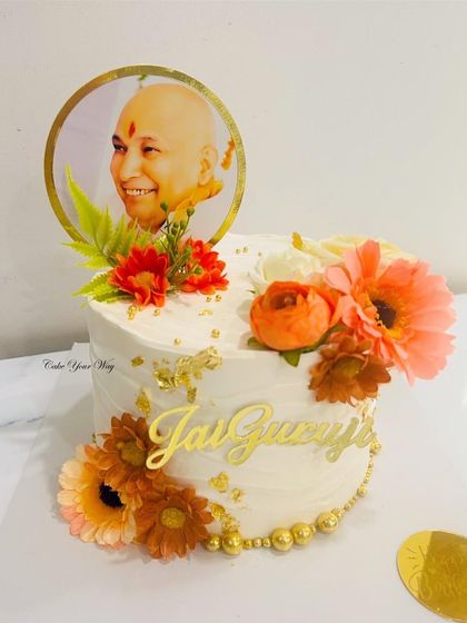 Crafted with care and adorned with blessings. Another beautiful "Jai Guruji" cake, this time in white with orange flowers and gold leaf.
