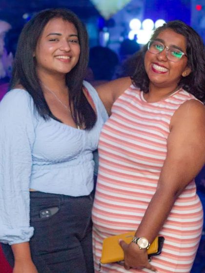 Two friends smiling and enjoying the party.