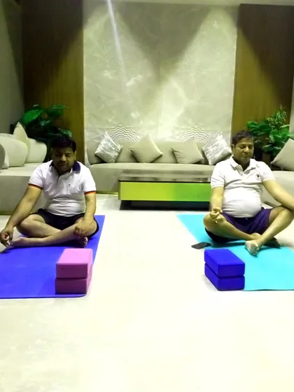 Two participants in a meditative pose after a dynamic session. I always end my classes with relaxation to integrate the benefits of the practice.