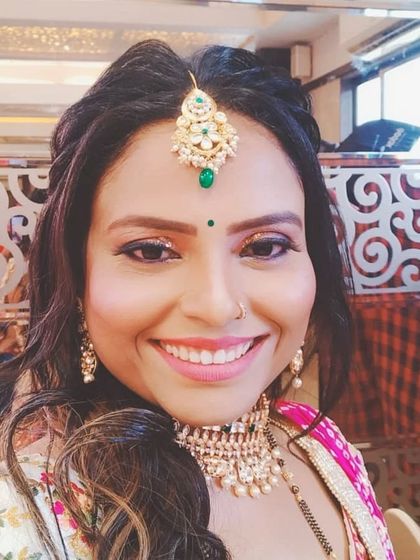 A smiling close-up that shows the maang tikka and choker in detail. A simple and elegant choice for any celebration.
