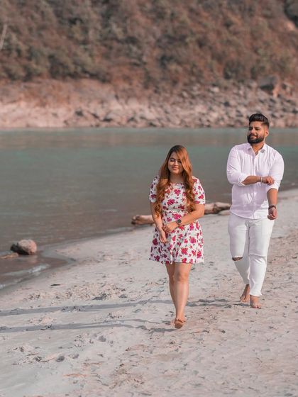 A relaxed walking shot of the couple on the sand, capturing the casual and comfortable vibe of their pre-wedding session.
