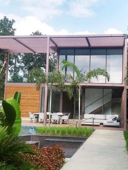 Surrounded by lush greenery, the home feels like a private resort. We design our structures to complement their environment, using landscaping and natural sightlines to create a sense of tranquility.