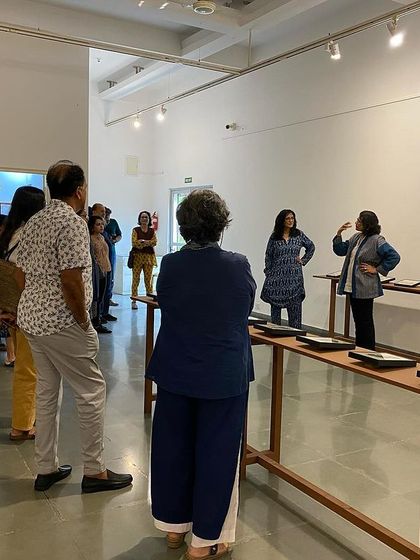 Pushpamala N. gesturing as she explains the nuances of the artwork.