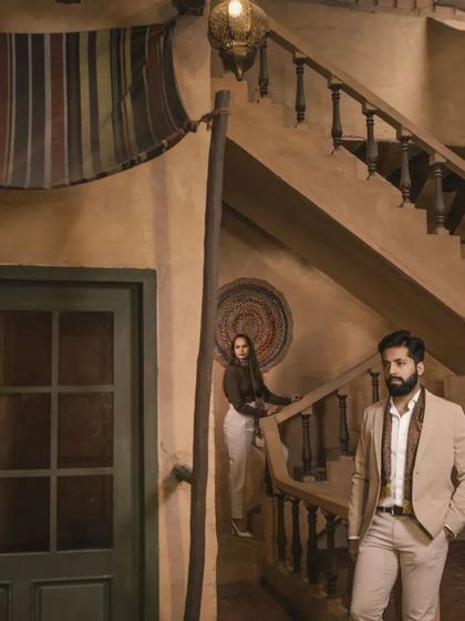 A candid-style shot on a staircase within a themed studio set, creating a sense of movement and narrative.