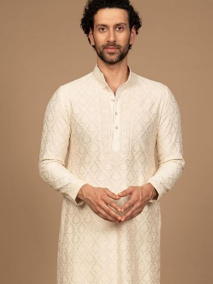An exquisitely embroidered ivory kurta. The delicate, tone-on-tone pattern creates a look of pure luxury and refined taste, perfect for the discerning gentleman.