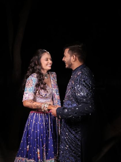 A candid moment of joy during a Dandiya night. The makeup is designed to look radiant and flawless even in low light, with a focus on glowing skin and defined eyes that sparkle as you celebrate.