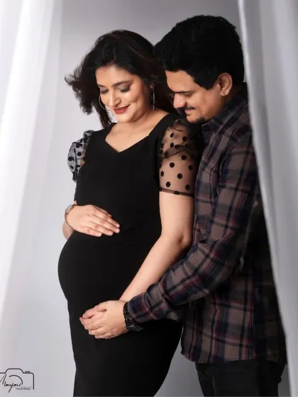 A loving embrace from her partner. This portrait beautifully showcases their connection against a simple, clean backdrop.