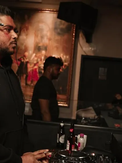 A candid moment at the booth, observing the dancefloor and planning my next move.