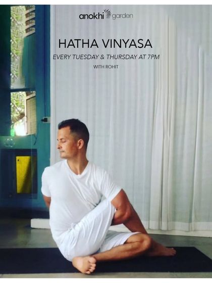 An instructor demonstrates a seated spinal twist in our Hatha Vinyasa class. This pose is excellent for improving spinal mobility and aiding digestion, reflecting the holistic benefits of our practices.