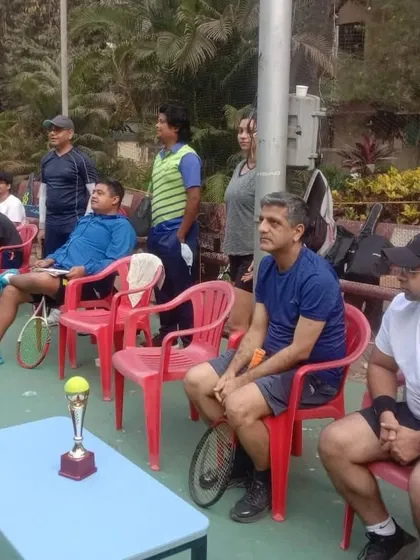 Players watching a match intently from the sidelines. We create an environment where participants are engaged throughout the day, both on and off the court.