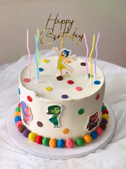 An "Inside Out" themed birthday cake made with my Belgian Chocolate flavor. It's decorated with colorful polka dots, character cutouts, and rainbow candles.