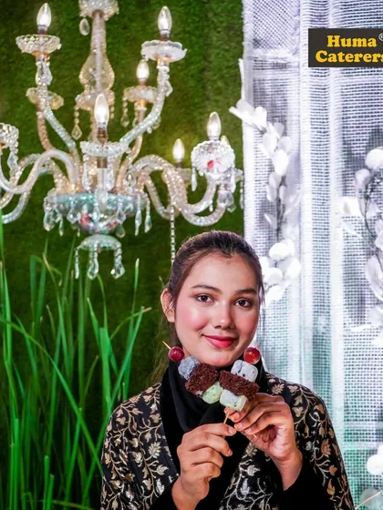 A guest enjoying our unique dango-style dessert skewer, showcasing our innovative approach to sweets.