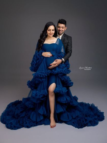 A glamorous couple's portrait. The rich royal blue of the gown pairs beautifully with the classic black suit for a sophisticated and elegant look.